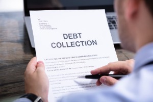 Businessman reading debt collection notice letter at desk