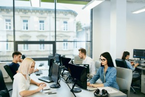 Internal sales people working in a modern office on phones and pcs