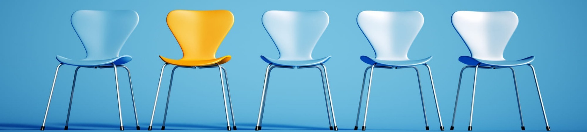 a row of blue chairs and a contrasting yellow one; indicating applicants awaiting a job interview