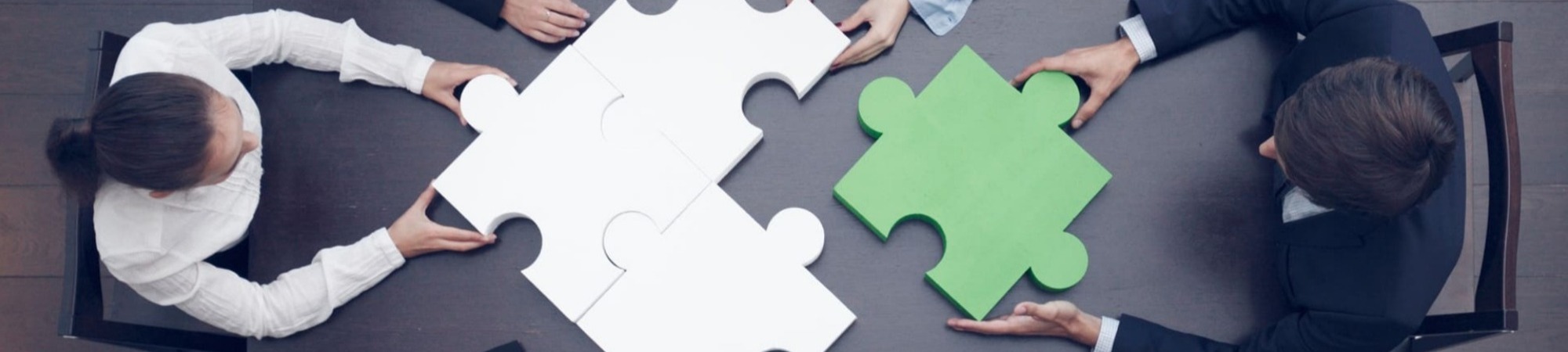 Group of business people assembling a jigsaw puzzle, team support and help concept.